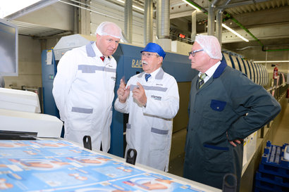 Fridolin Leis (centre) managing director of CARTONIC Packaging Group explains the production processes at the plant in Emskirchen to Michael Stürmer (l) and Werner Dengel from KBA-Deutschland. The raised seven-colour Rapida 106 with two coaters can be seen in the backgroun